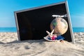 Summer background table. Globe, seashell, airplane and starfish near black desk on sea beach in sunny day. Copy space of summer Royalty Free Stock Photo