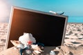 Summer background table. Globe, seashell, airplane and starfish near black desk on sea beach in sunny day. Copy space of summer Royalty Free Stock Photo