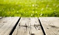 Summer background. Wooden table and green grass in bokeh with sunlight. Royalty Free Stock Photo