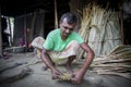 A worker is busy in making hand held fan.