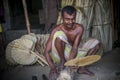 A worker is busy in making hand held fan.