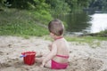 In the summer on the banks of the river a little baby dig sand Royalty Free Stock Photo