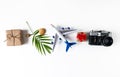 Summer banner with a camera, a palm leaf, an airplane, shells, a gift on a white background