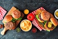 Summer BBQ hamburger table scene, top view over slate