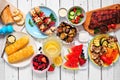 Summer BBQ or picnic food top down view table scene on a white wood background