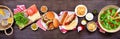 Summer BBQ or picnic table scene with hamburgers and hotdogs, over a dark wood banner background Royalty Free Stock Photo