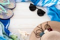 Summer beach accessories. Colorful flip flops, shell, black sunglasses, blue pareo and straw hat on a wood background. The concept Royalty Free Stock Photo