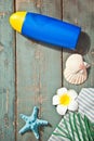 Summer beach accessories. Tube of sunscreen, starfish, plumeria frangipani and seashells. Mock up. Copy space.