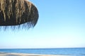 Summer beach background, with parasol and blue sky.