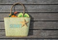 Summer beach bag with text sunny on wood background.