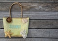 Summer beach bag with text sunny on wood background.