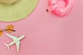 Summer beach composition. Minimal simple flat lay with plane sunglasses hat and Inflatable flamingo isolated on pastel pink