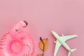 Summer beach composition. Minimal simple flat lay with plane sunglasses and Inflatable flamingo isolated on pastel pink background