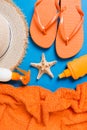 Summer beach flat lay accessories. Sunscreen bottle cream, straw hat, flip flops, towel and seashells on colored Background. Royalty Free Stock Photo