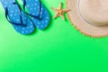 Summer beach flat lay accessories. Sunscreen straw hat, flip flops and seashells on colored Background. Travel holiday concept Royalty Free Stock Photo