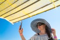 Summer beach holidays. on the beach, a red-haired girl with freckles on her face in a hat with a large brim and a light Royalty Free Stock Photo