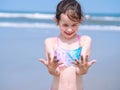 Summer beach - Little girl have a good time of resort beach. Kid playing on sandy beach. Focus on the hand Royalty Free Stock Photo