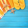 Summer beach objects border, flip flops, starfish blue wood background Royalty Free Stock Photo