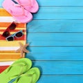 Summer beach objects border, sunglasses, flip flops, blue wood background copy space Royalty Free Stock Photo