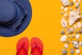 Summer beach sea accessories. Coral flip flops, blue straw hat, sunglasses, shells, starfish on yellow background top view flat Royalty Free Stock Photo