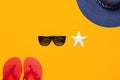 Summer beach sea accessories. Coral flip flops, blue straw hat, sunglasses, shells, starfish on yellow background top view flat Royalty Free Stock Photo