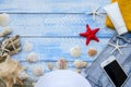 Summer beach sea concept. Blue Wooden background with different accessories, shells, starfish, towel, sunscreen, sand Royalty Free Stock Photo