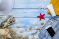 Summer beach sea concept. Blue Wooden background with different accessories, shells, starfish, towel, sunscreen, sand Royalty Free Stock Photo