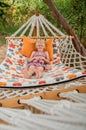 Summer beach tropical vacation with kids. Cute happy little caucausian girl laying in a hammock Royalty Free Stock Photo