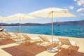 Summer beach vacation. Lounge chairs and white sun umbrellas against blue sky. Montenegro, Tivat city Royalty Free Stock Photo