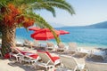 Summer beach vacation.  Sunny Mediterranean landscape with red beach umbrellas. Montenegro, Bay of Kotor Royalty Free Stock Photo