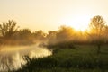 summer beautiful foggy dawn on the river. The sun rising in the fog over the horizon. Beautiful landscape in the early morning. Royalty Free Stock Photo