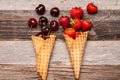 Summer berries in ice cream cones on wooden background. Royalty Free Stock Photo