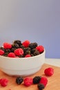 Summer berries in a pialat on wooden background