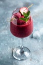 Summer berries smoothie strawberries and raspberry in glass with mint leaf and raw beeries on blue background. vertical image. top Royalty Free Stock Photo