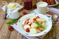 Summer berry breakfast. Sweet lazy pierogi, dumplings with sour cream, butter and strawberry on wooden background. Italian gnocchi