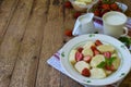 Summer berry breakfast. Sweet lazy pierogi, dumplings with sour cream, butter and strawberry on wooden background. Italian gnocchi