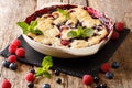 Summer berry cake with raspberry berries, currants and blueberries close-up in a baking dish. horizontal Royalty Free Stock Photo