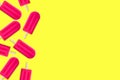 Summer border of pink popsicles on a yellow background