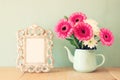 Summer bouquet of flowers and victorian frame on the wooden table with mint background. vintage filtered image Royalty Free Stock Photo