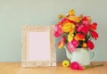 Summer bouquet of flowers and victorian frame on the wooden table with mint background. vintage filtered image Royalty Free Stock Photo