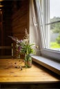 Summer bouquet of flowers at the window of the cottage, rural still life. Rustic style, vintage colors. Selective focus Royalty Free Stock Photo