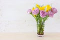 Summer bouquet of pink roses and yellow calla lily flowers in the vase over wooden table and white old background Royalty Free Stock Photo