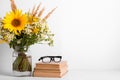 Summer bouquet of wildflowers in glass vase, old books on rustic background. Season design concept. Teachers day concept, back to Royalty Free Stock Photo