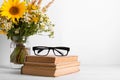 Summer bouquet of wildflowers in glass vase, old books on rustic background. Season design concept. Teachers day concept, back to Royalty Free Stock Photo