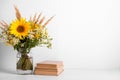 Summer bouquet of wildflowers in glass vase, old books on rustic background. Season design concept. Teachers day concept, back to Royalty Free Stock Photo