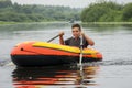 In summer, the boy floats on the river in an inflatable boat. He shows his hand super Royalty Free Stock Photo