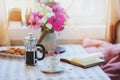 summer breakfast in cozy country house. Table with bouquet of flowers from own garden, french press with coffee and cookies.