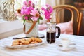 Summer breakfast in cozy country house. Table with bouquet of flowers from own garden, french press with coffee and cookies.