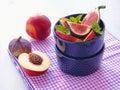 Summer breakfast. Ripe fruits with mint leaves and thyme sprig in violet vase. Fruit salad. Assorted summer fruits. Figs and peach