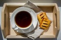 Summer breakfast. White cup with tea, butter biscuits on a wooden tray on a white table. View from above Royalty Free Stock Photo